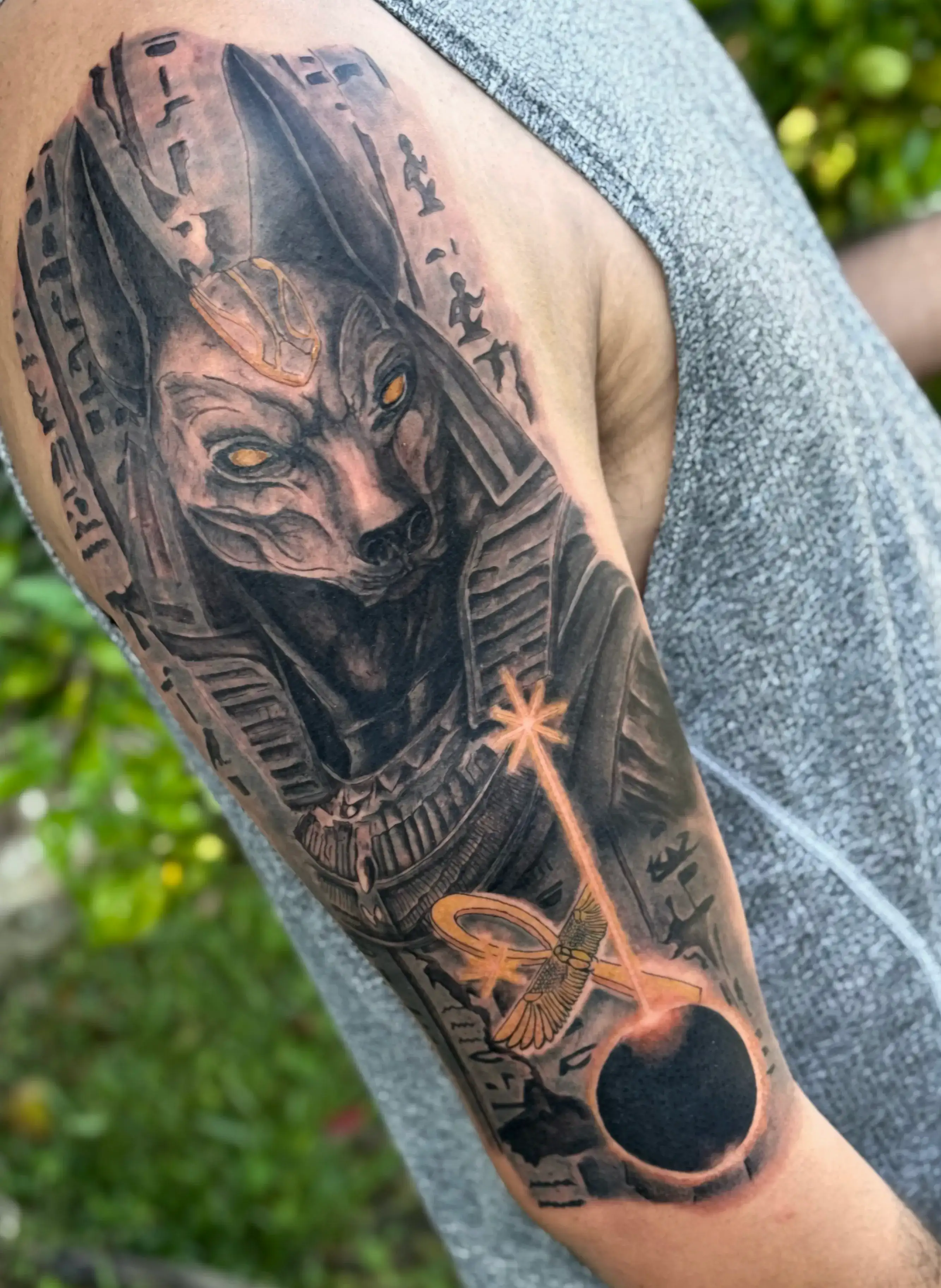 Tatuaje neorealista Dios Anubis black and gray con un color agregado